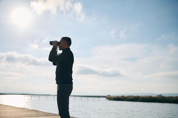 Mann mit Fernglas am Neuen Strand